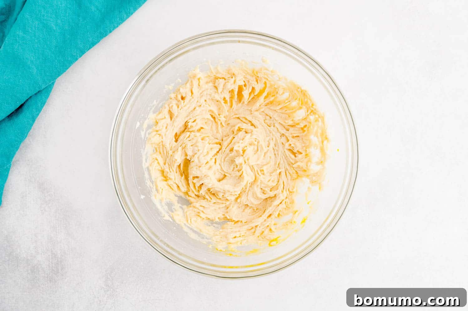 The perfectly combined wet ingredients for chocolate peppermint sugar cookies, a creamy mixture of butter, sugar, egg, and extracts, in a clear glass mixing bowl, ready for the dry components.