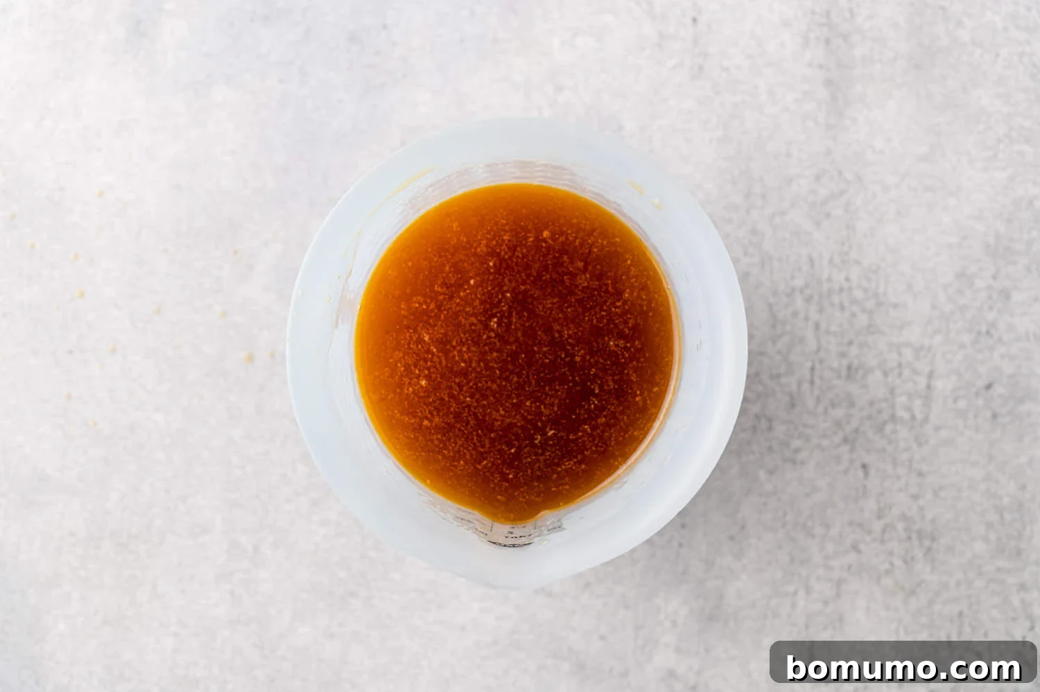 Chicken broth and drippings in a measuring cup.