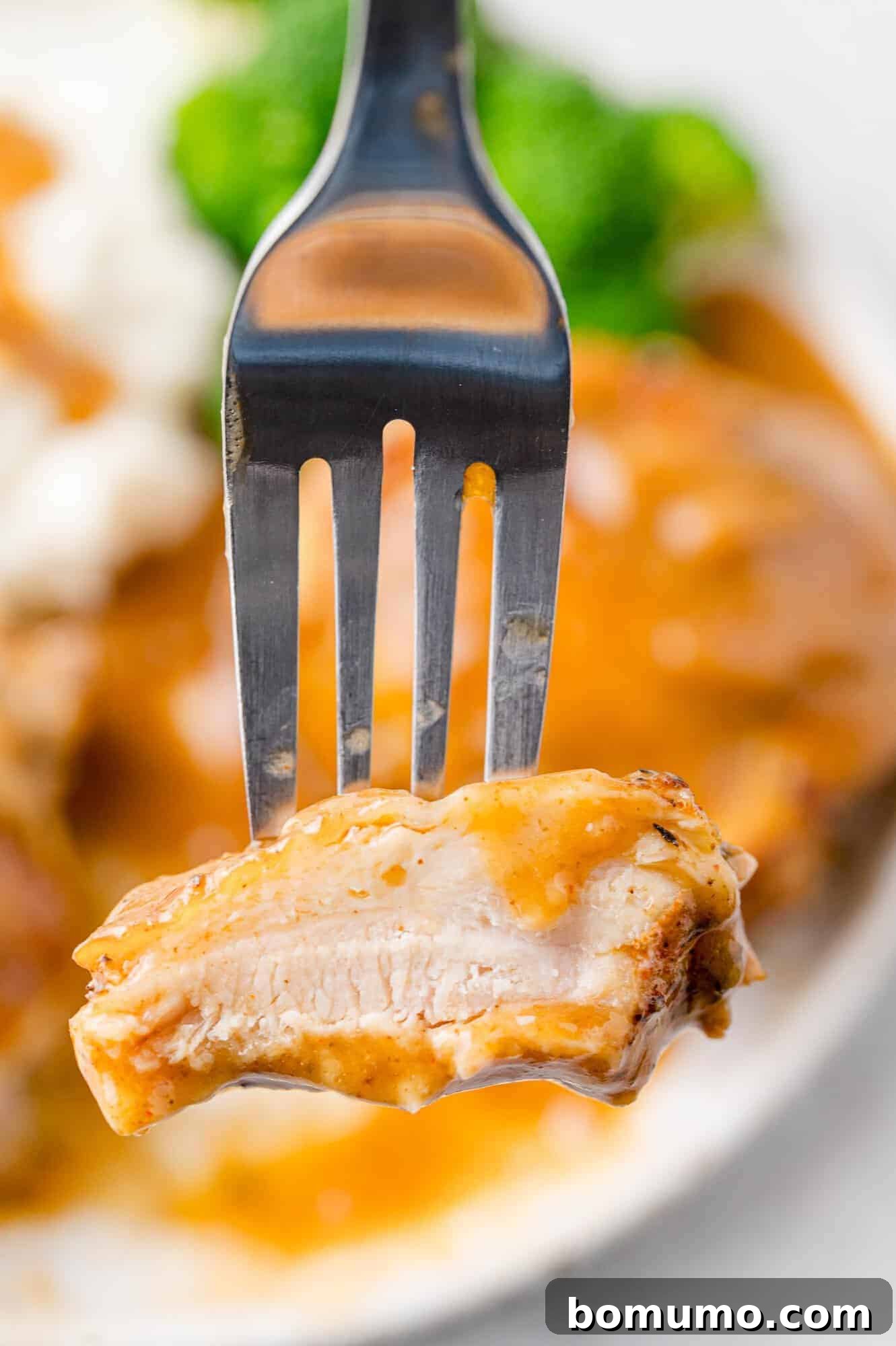 Chicken thigh on fork, cut to show inside.