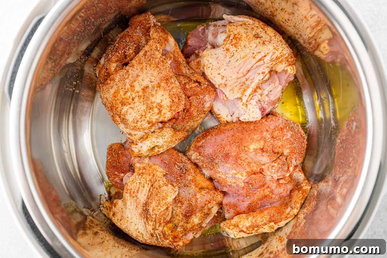 Chicken thighs being browned on the first side in the Instant Pot.