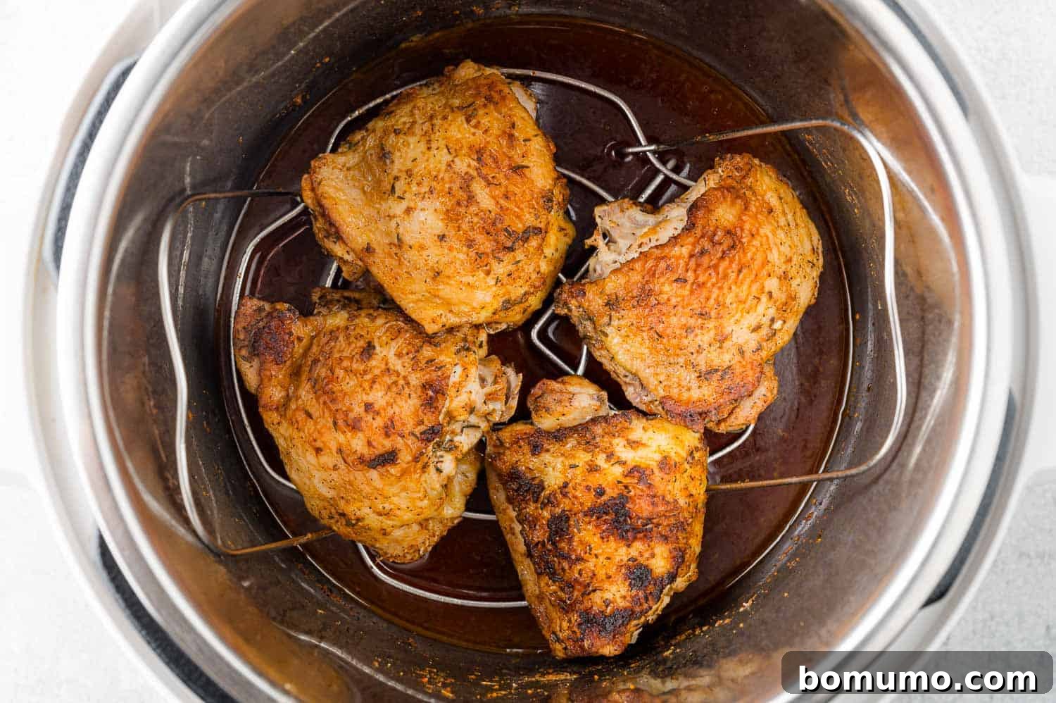 Chicken thighs and trivet added to Instant Pot.