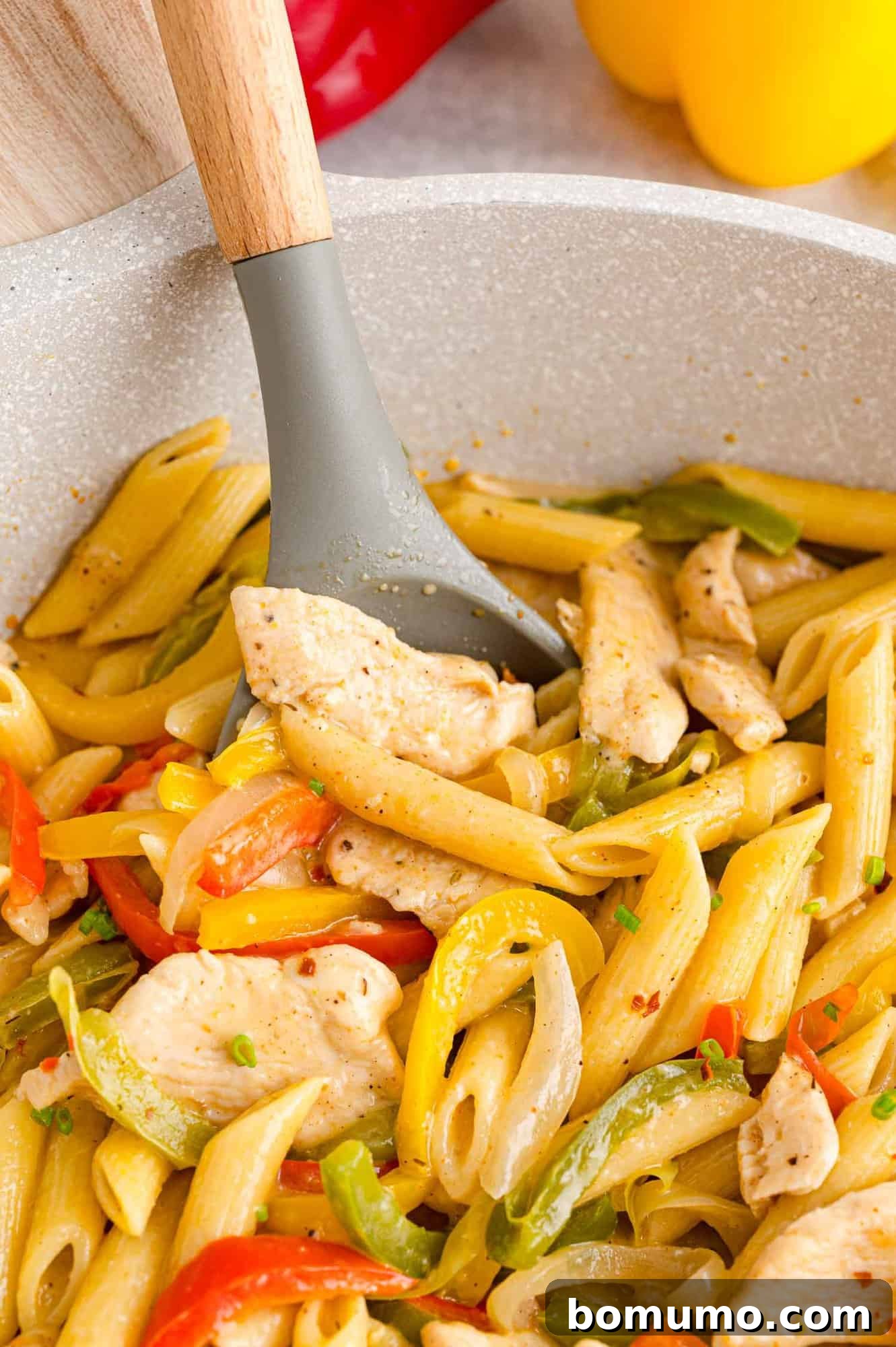 Close up of Rasta Pasta in a pot with a serving spoon.