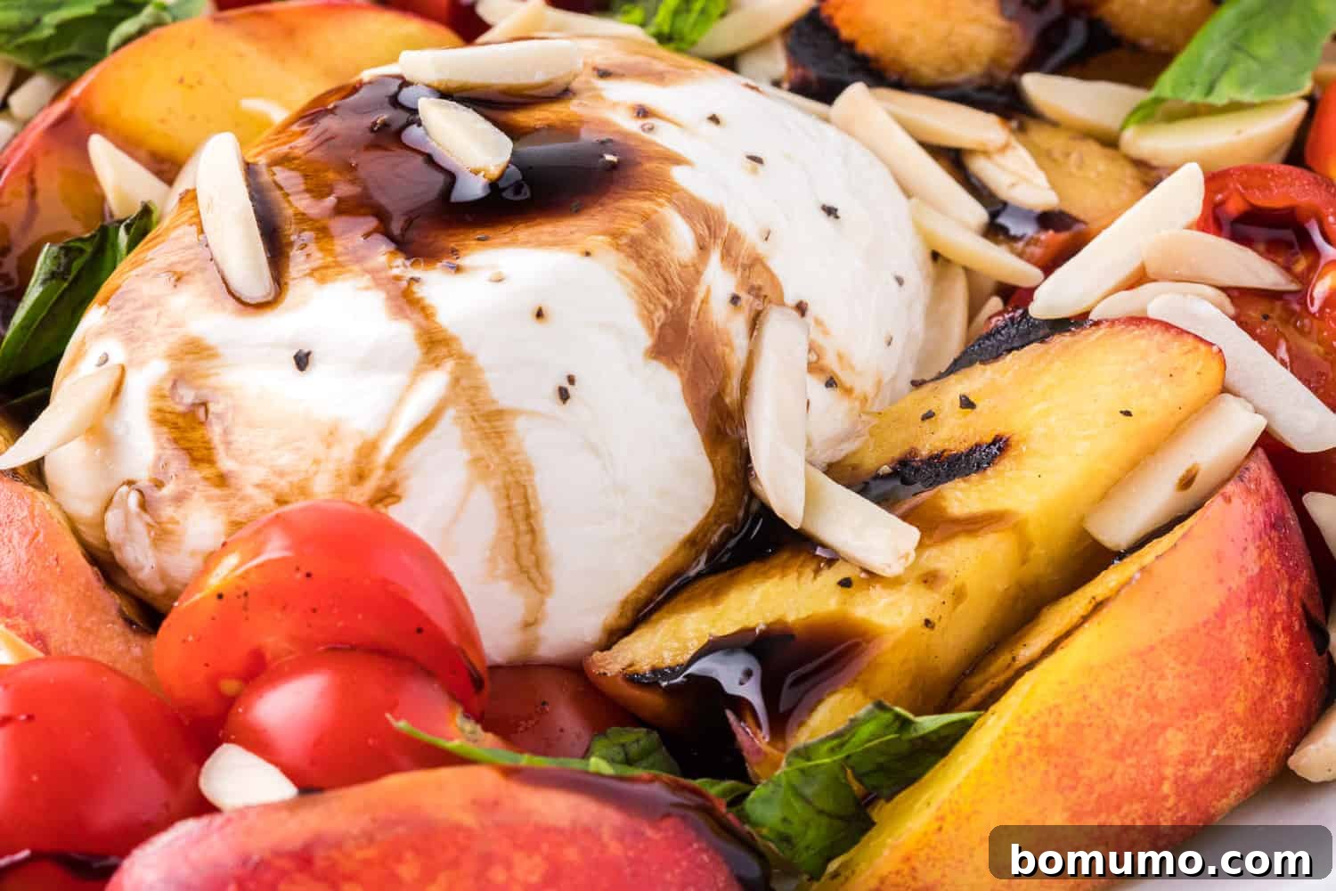 A close-up view of creamy burrata cheese generously drizzled with rich balsamic glaze, showcasing its inviting texture.