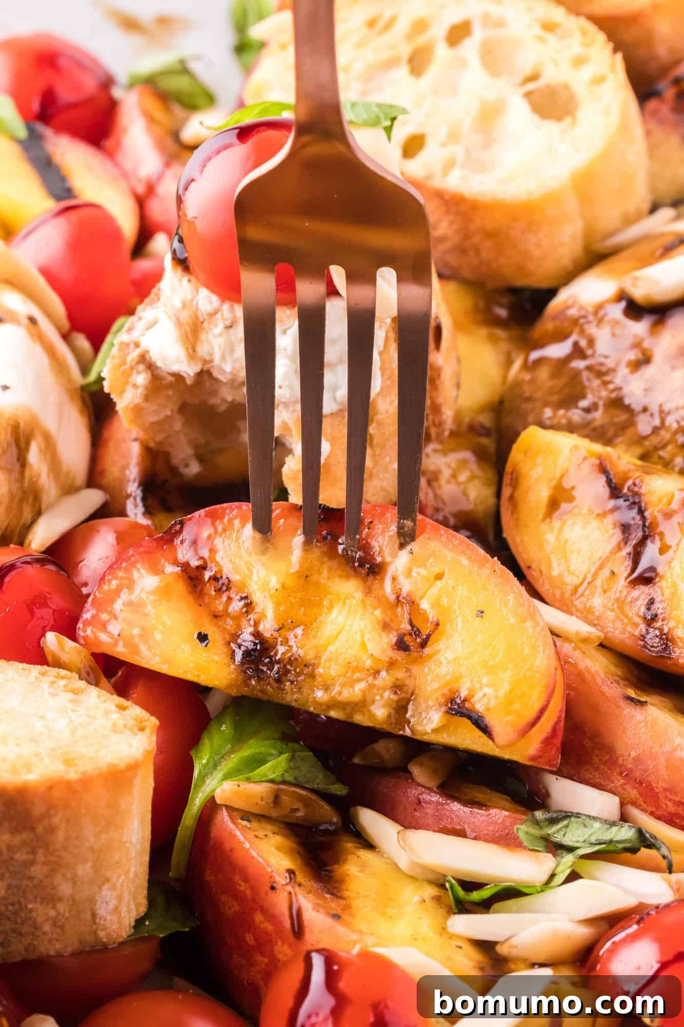 A close-up shot of a perfectly grilled peach slice held on a fork, showcasing its caramelized edges and juicy texture.