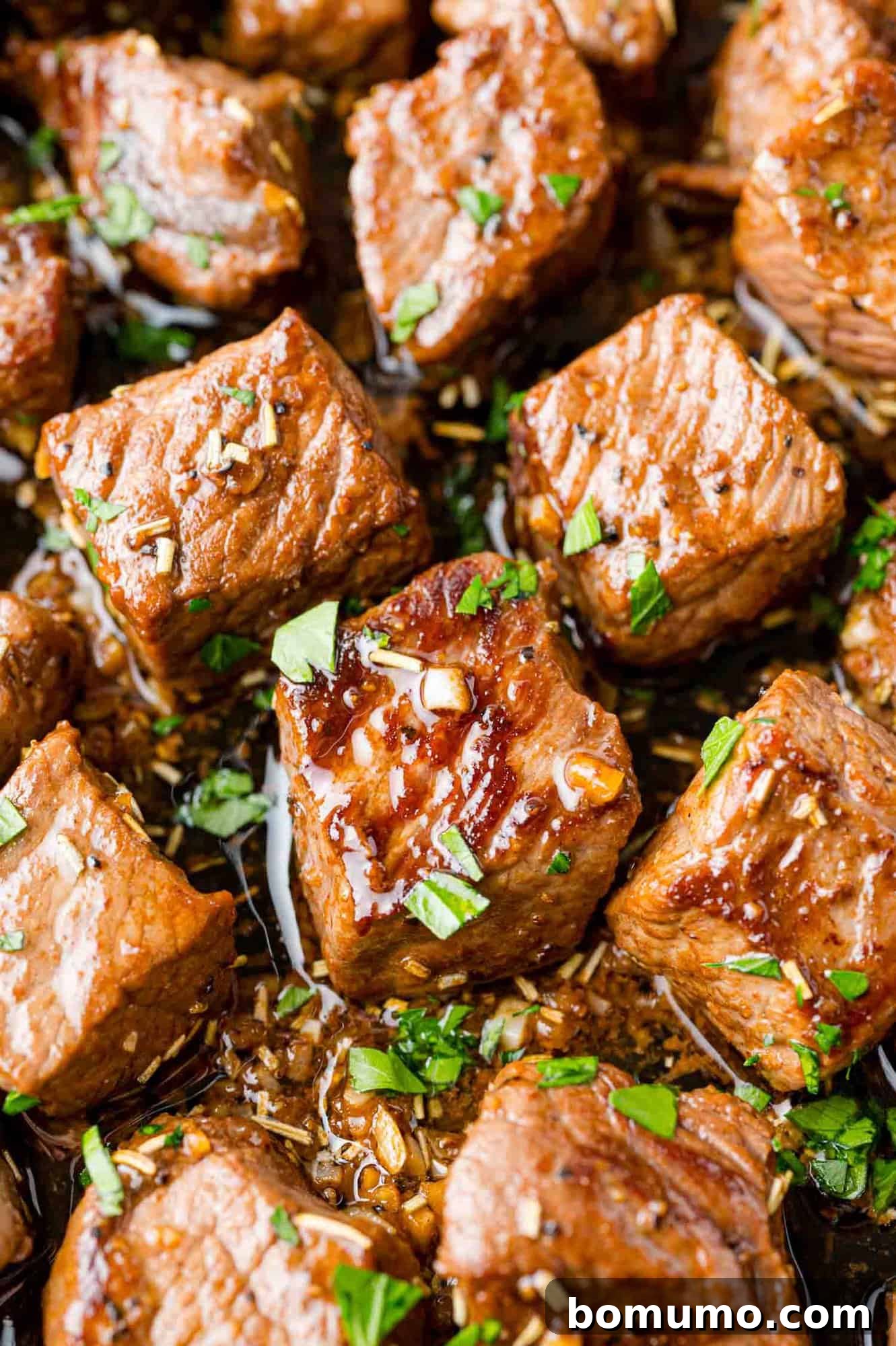 Garlic butter steak bites sprinkled with fresh parsley, presented beautifully.
