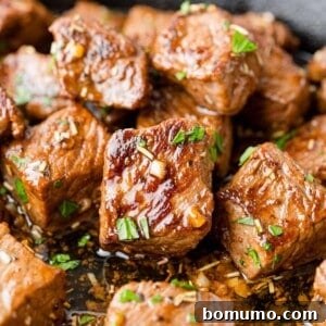 Garlic butter steak bites, sprinkled with fresh parsley and glistening with sauce.