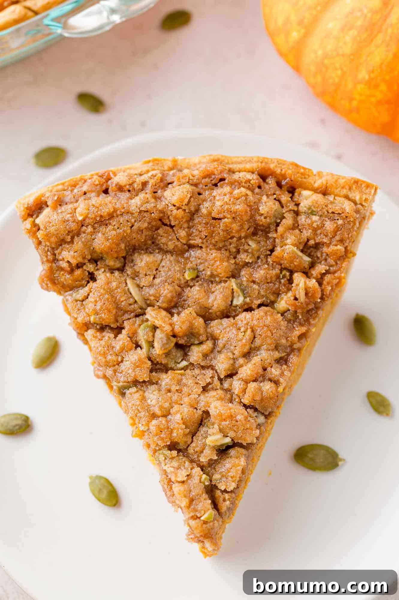 Overhead view of a slice of streusel topped pumpkin pie.