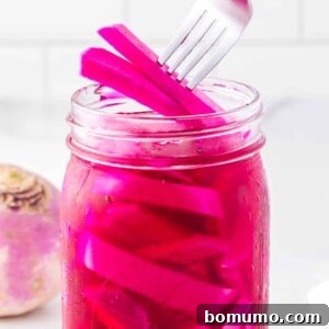 Pickled turnips being lifted from a jar with a fork.
