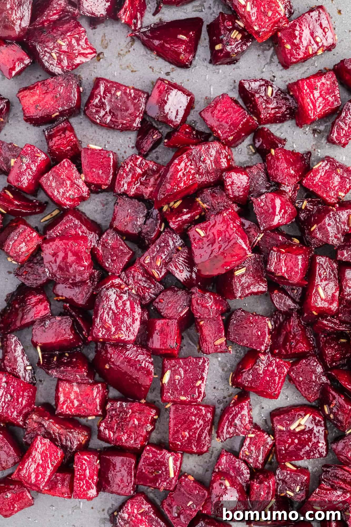 Overhead view of chopped roasted beets, showing their vibrant color and slightly caramelized edges.