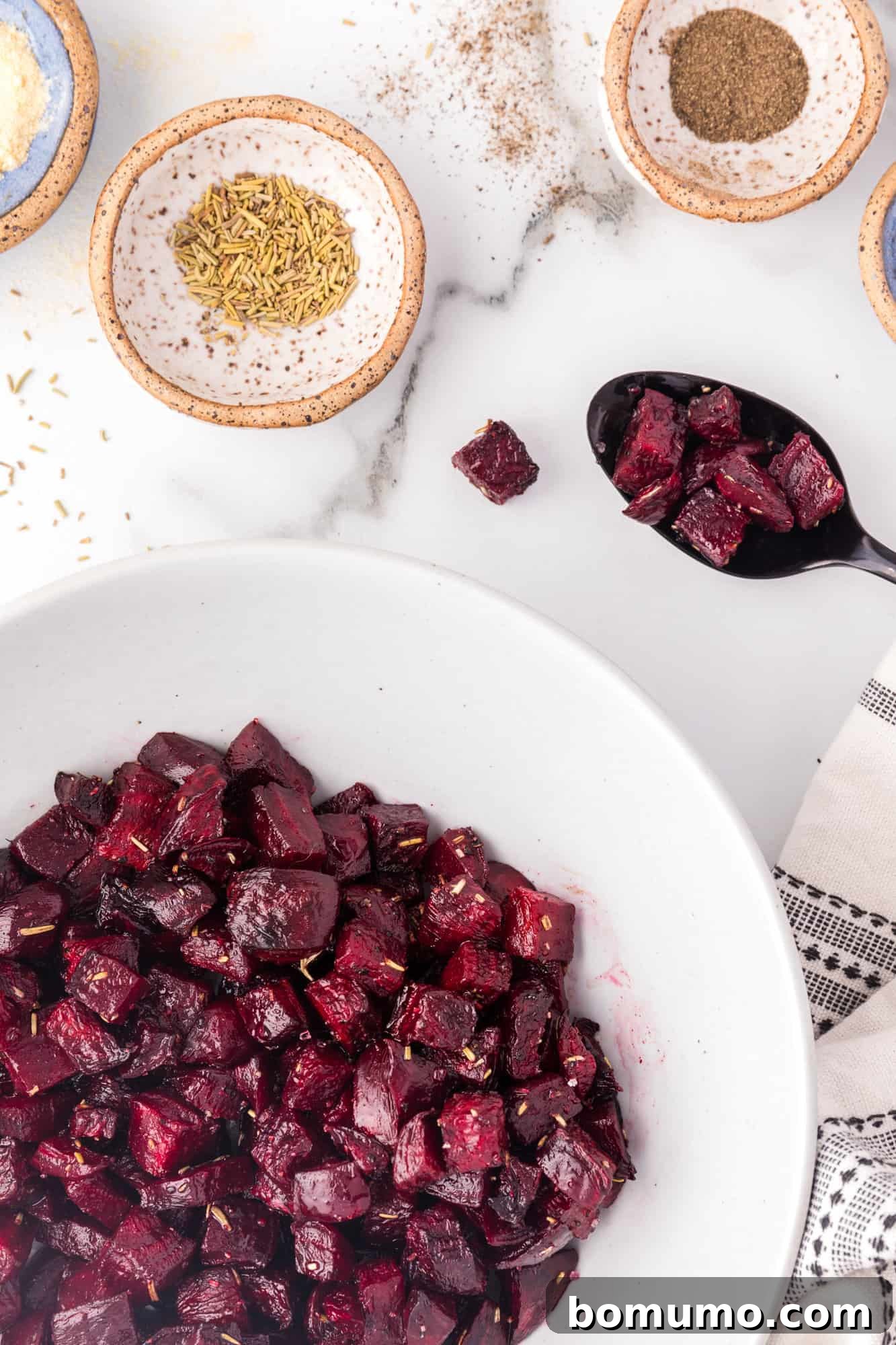 A white bowl filled with glistening, perfectly roasted beet cubes, ready to be served.