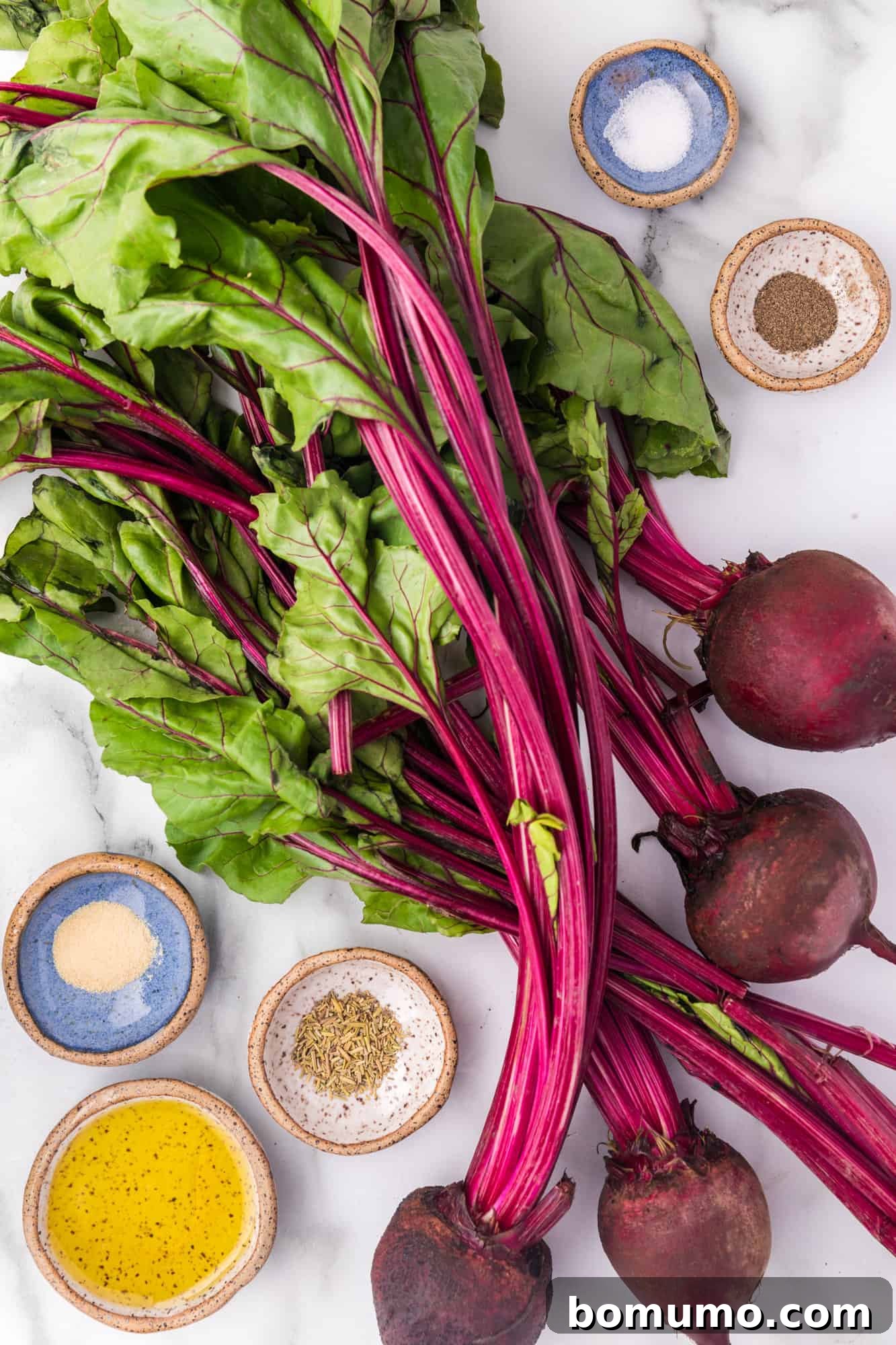 An overhead shot of all the simple ingredients required for the roasted beet recipe laid out on a surface.
