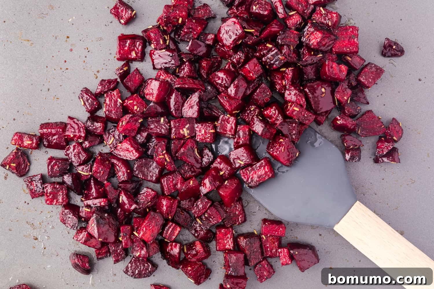 Golden-brown and tender roasted beets spread on a sheet pan, fresh out of the oven.