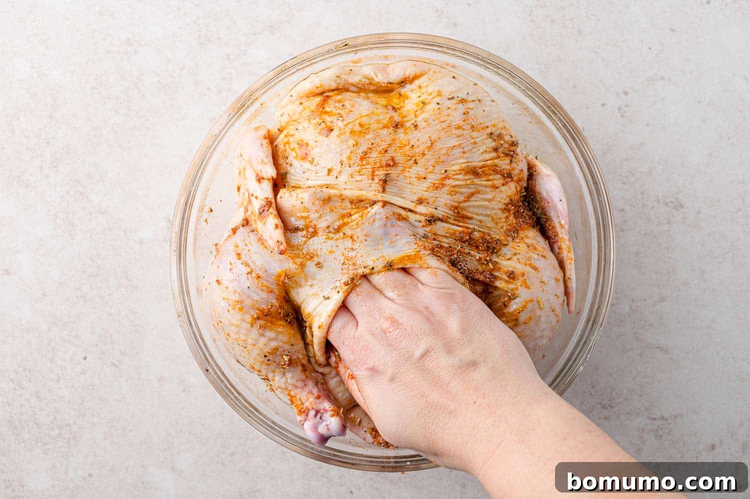 Spice rub being added under skin of chicken.