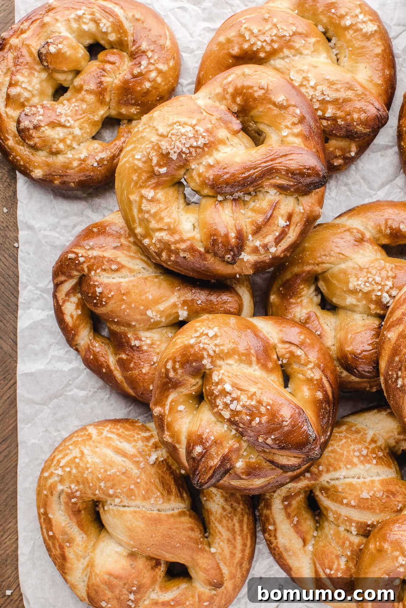 A tray of golden-brown homemade soft pretzels, freshly baked and lightly salted.