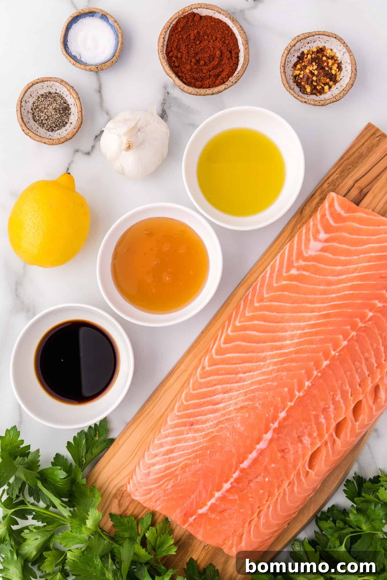 Ingredients needed for honey garlic salmon, including a large filet of salmon, honey, soy sauce, garlic, and seasonings.