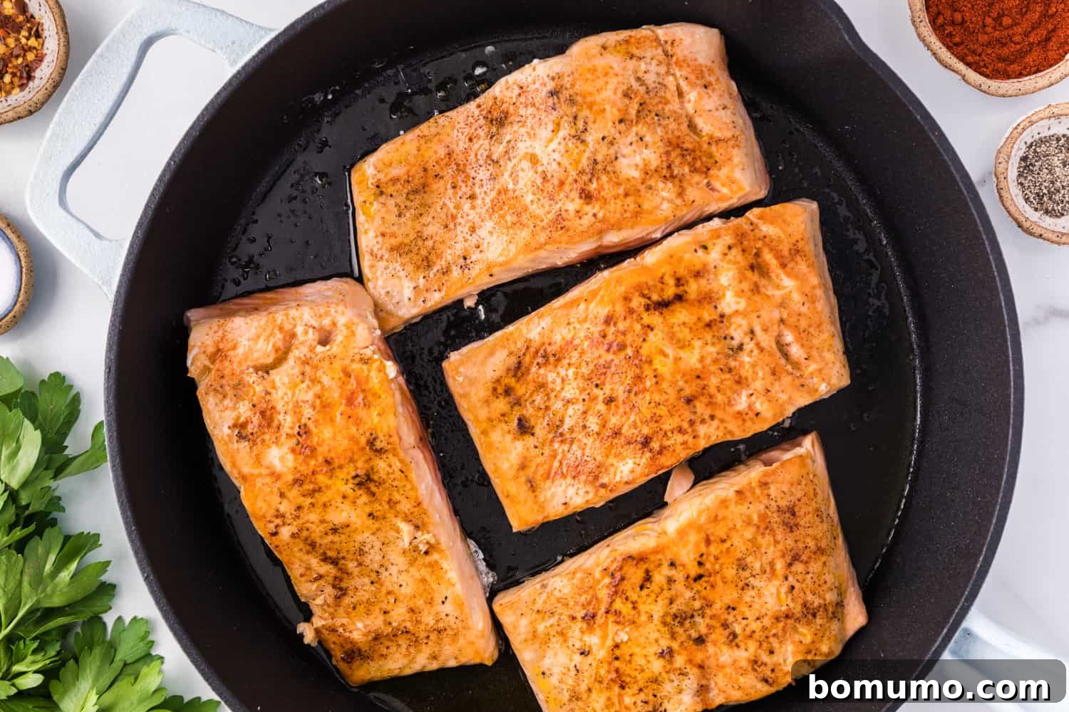 Seared salmon fillets, showing a beautiful golden-brown crust.