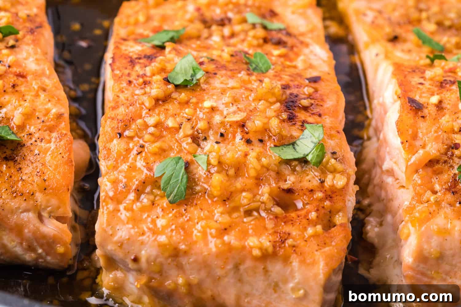 Close-up view of a perfectly cooked salmon fillet with honey garlic glaze, ready to be enjoyed.