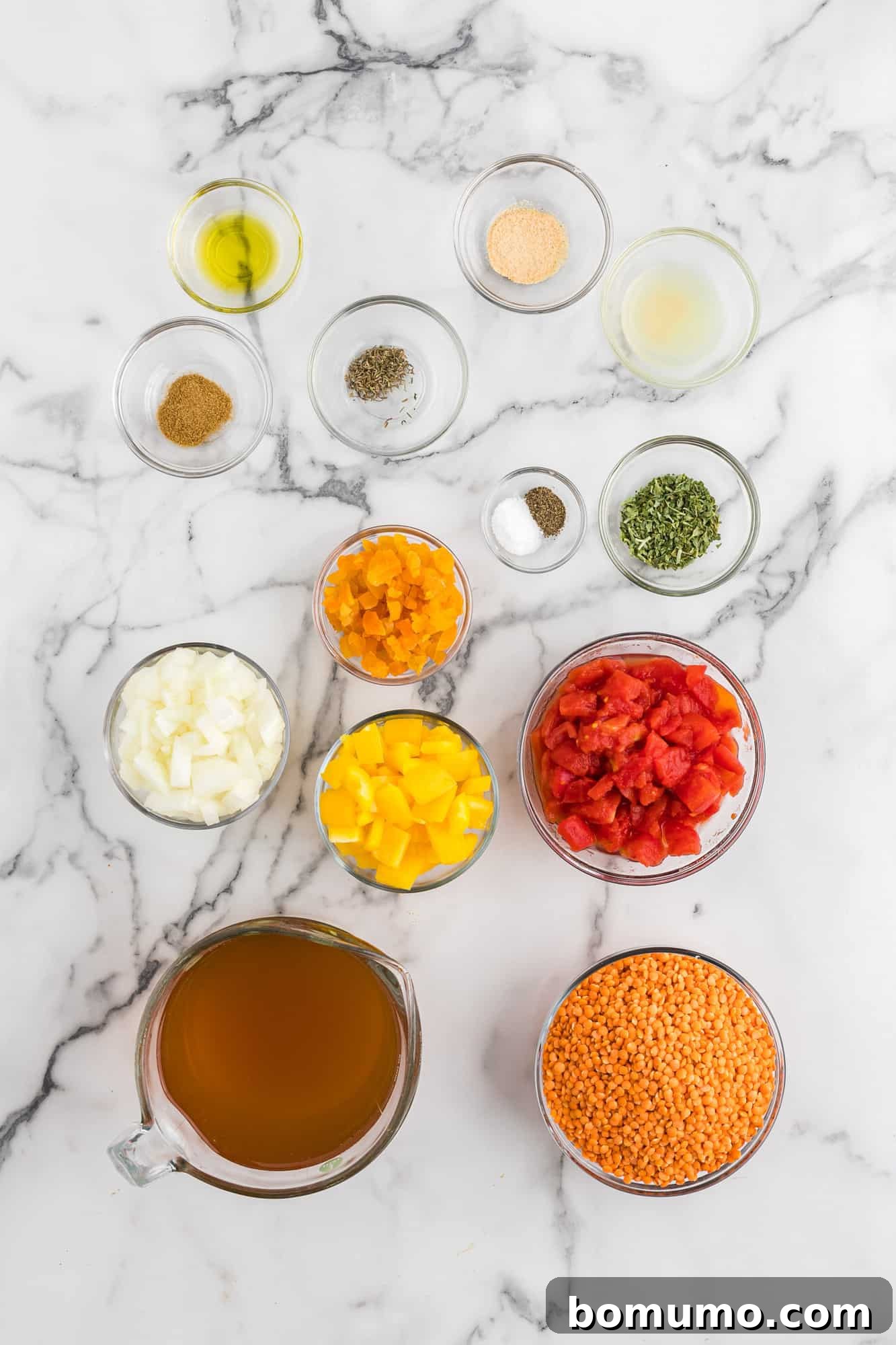 An overhead shot showcasing all the fresh and dry ingredients meticulously laid out for the red lentil soup recipe.