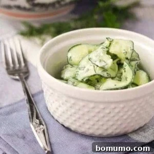 Small white serving bowl with cucumber salad.