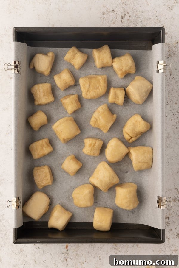 Boiled pretzel bites on a parchment-lined baking sheet.