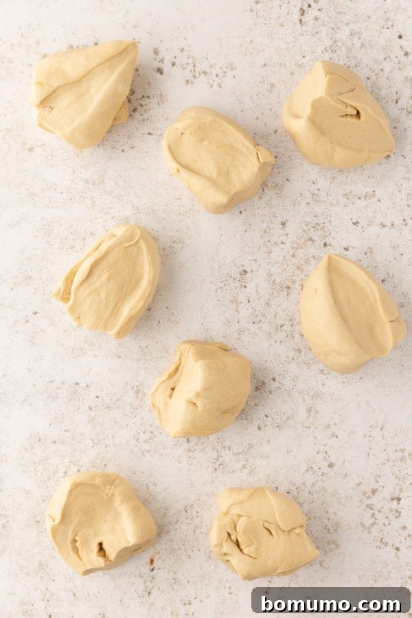 Pretzel dough portioned into pieces on a countertop.
