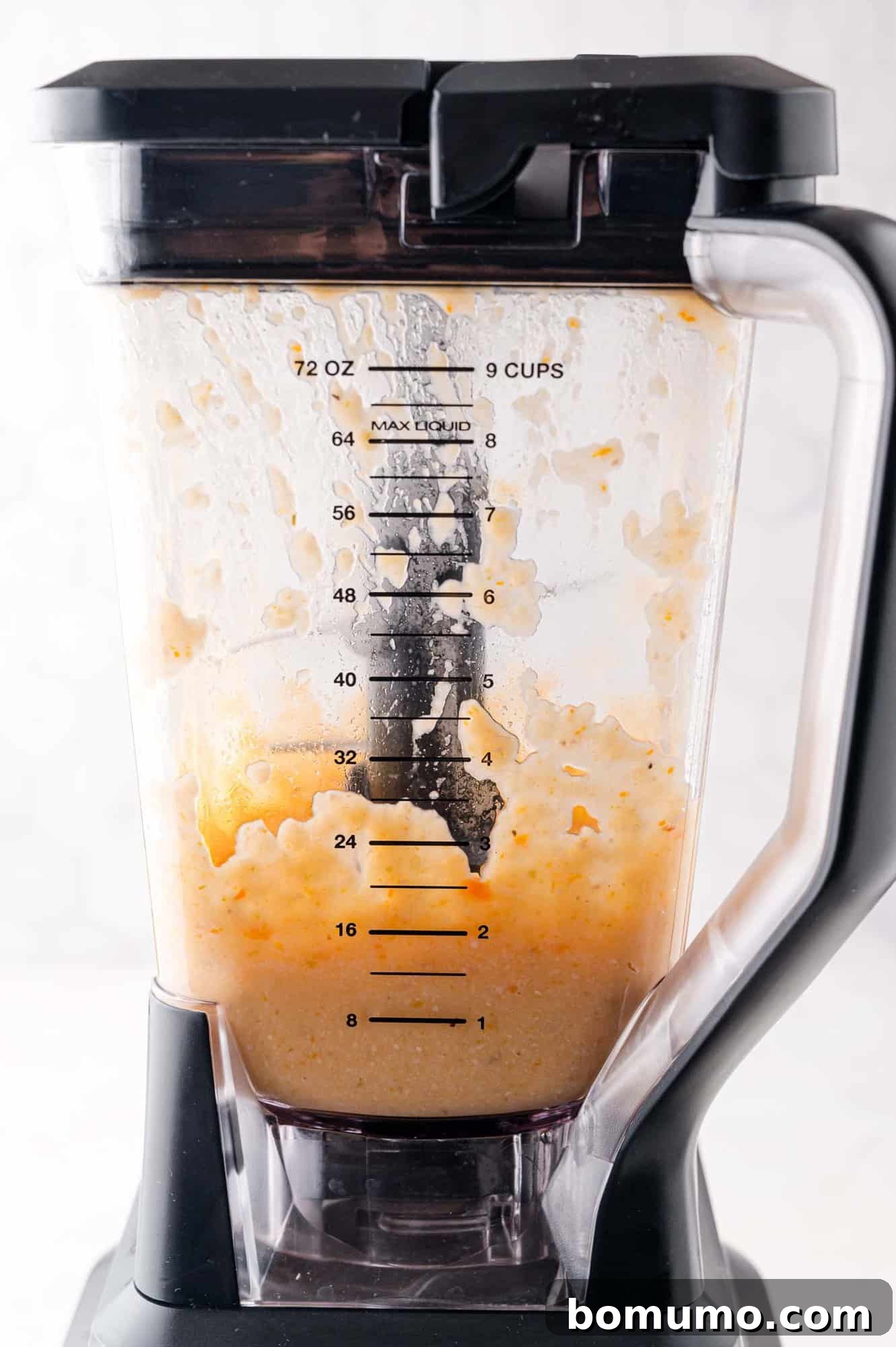 A blender filled with a creamy, orange mixture.