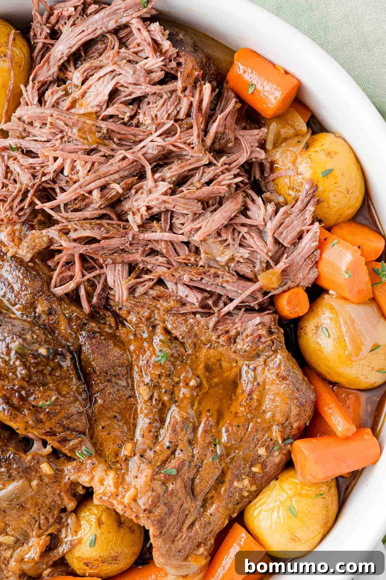 Pot roast, partially shredded, with potatoes and carrots.