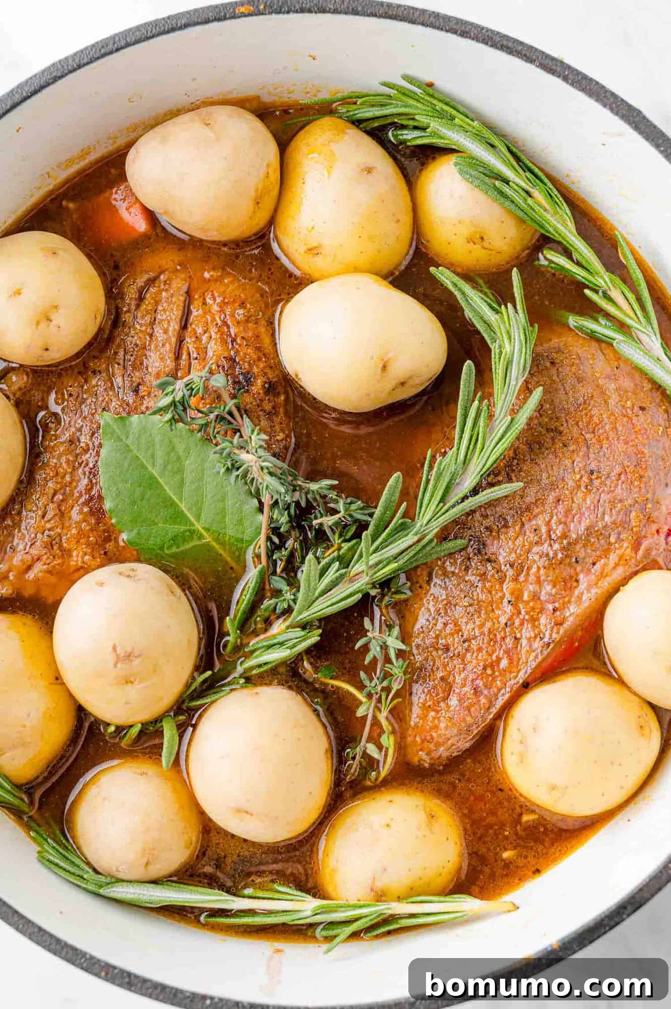 Herbs and potatoes added to pan.