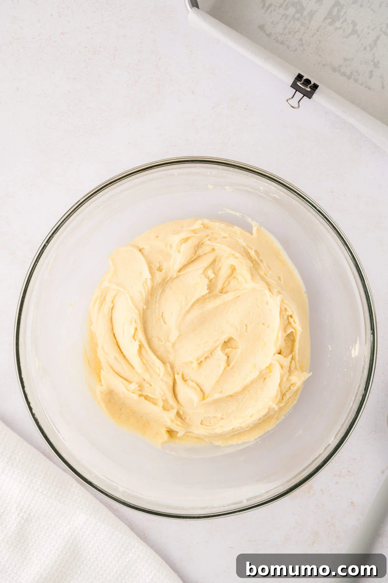 The fully mixed, thick lemon brownie batter resting in a clear glass mixing bowl.