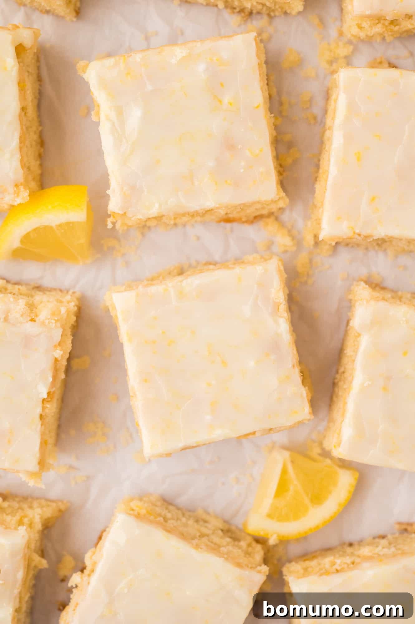 Overhead view of perfectly cut lemon brownies, arranged neatly on parchment paper, ready to serve.