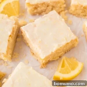 Lemon brownies with glaze, cut into squares on parchment paper, ready to be served.