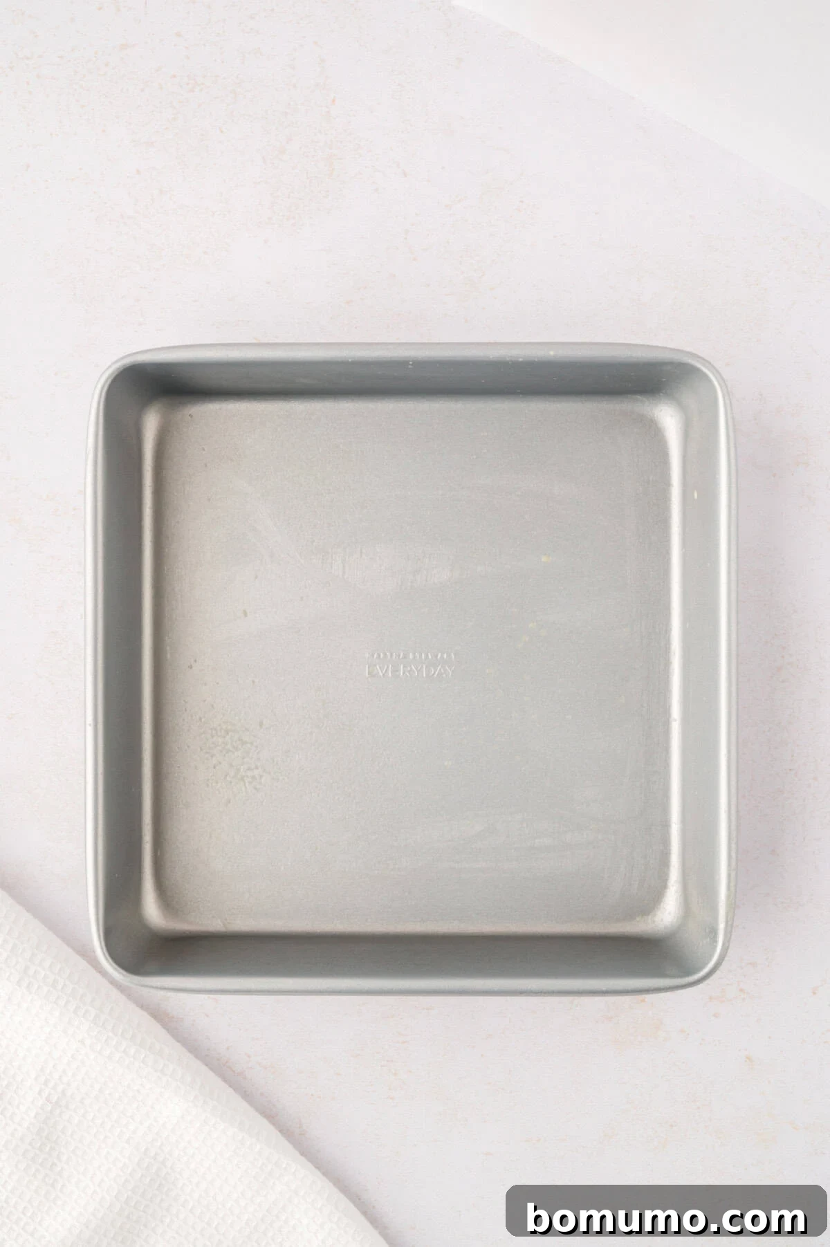 An empty square metal baking dish, ready for preparation.