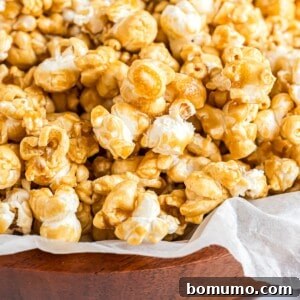Homemade caramel corn in a parchment paper lined wooden bowl.