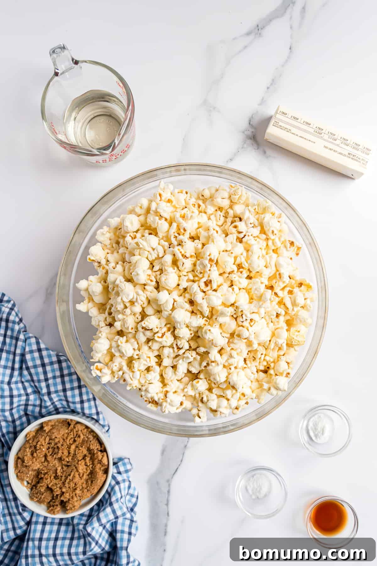 An overhead shot showcasing all the essential ingredients meticulously laid out for a homemade caramel corn recipe.
