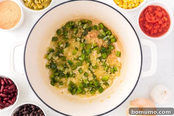Diced onions and bell pepper gently sauteing in a large pot, beginning to soften.