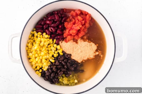 A large pot filled with all the vibrant ingredients for chicken taco soup, ready to be cooked.