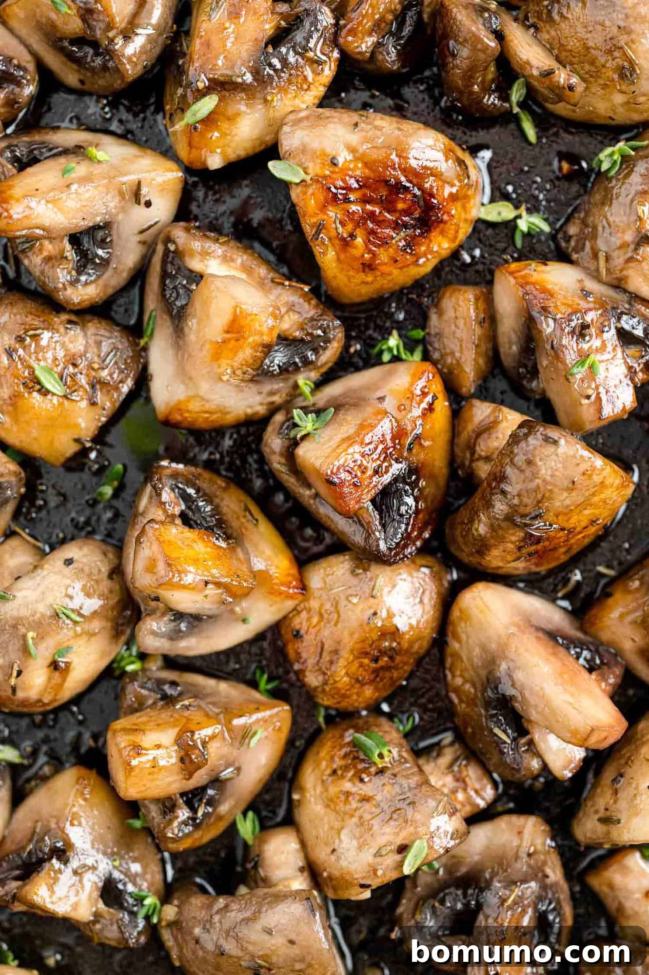 Sautéed mushrooms with marsala, filling the frame, sprinkled with fresh herbs, showcasing their rich color and tender texture.
