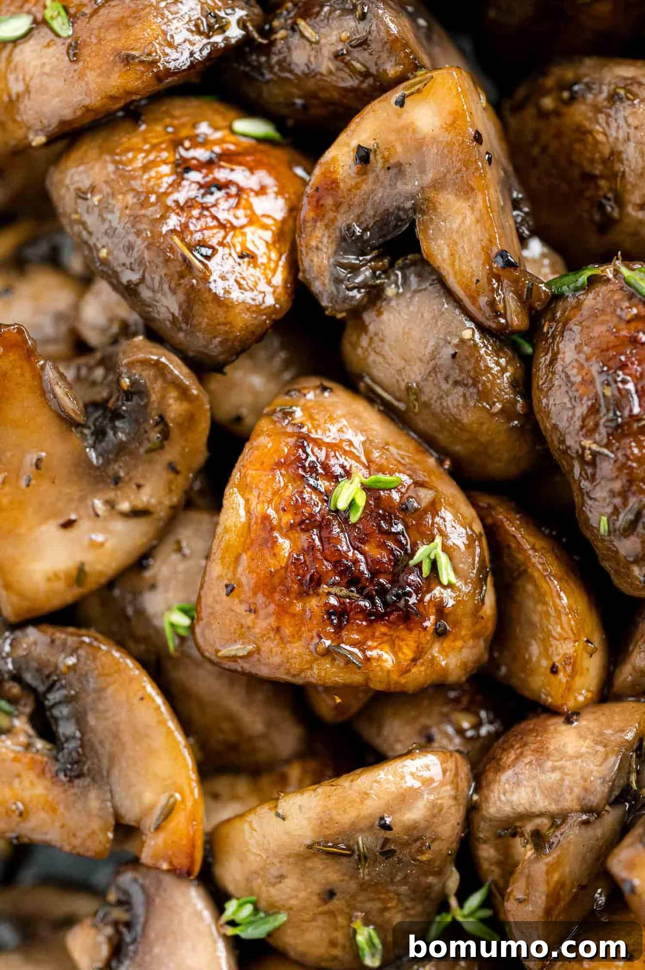 A close-up of perfectly browned mushrooms, glistening with moisture and flavor, highlighting their appetizing texture and color.