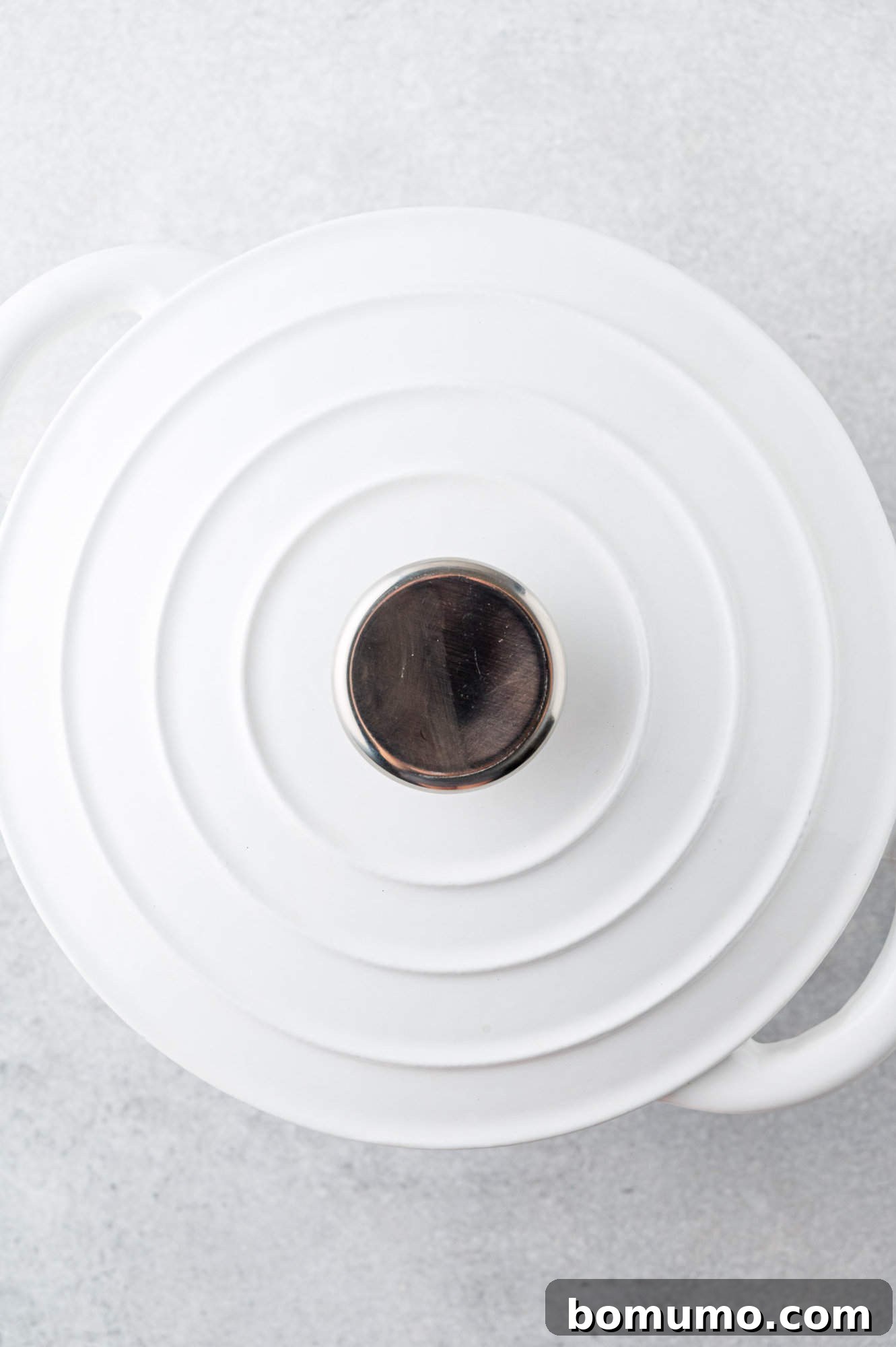 A large Dutch oven with its lid tightly on, simmering jasmine rice on a stovetop.