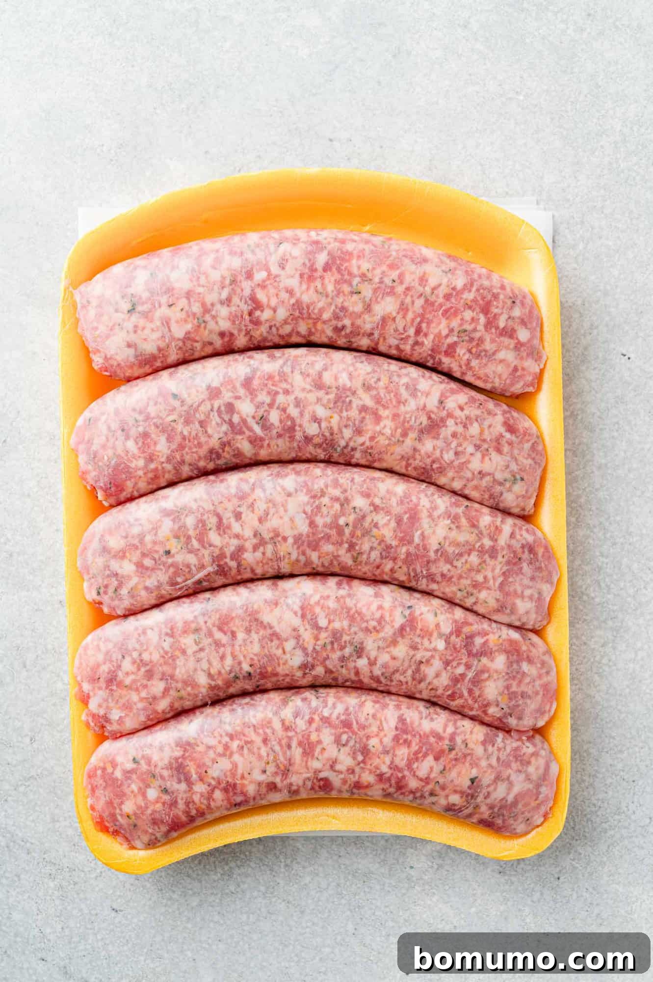 Uncooked Italian sausage in styrofoam package, plastic removed.