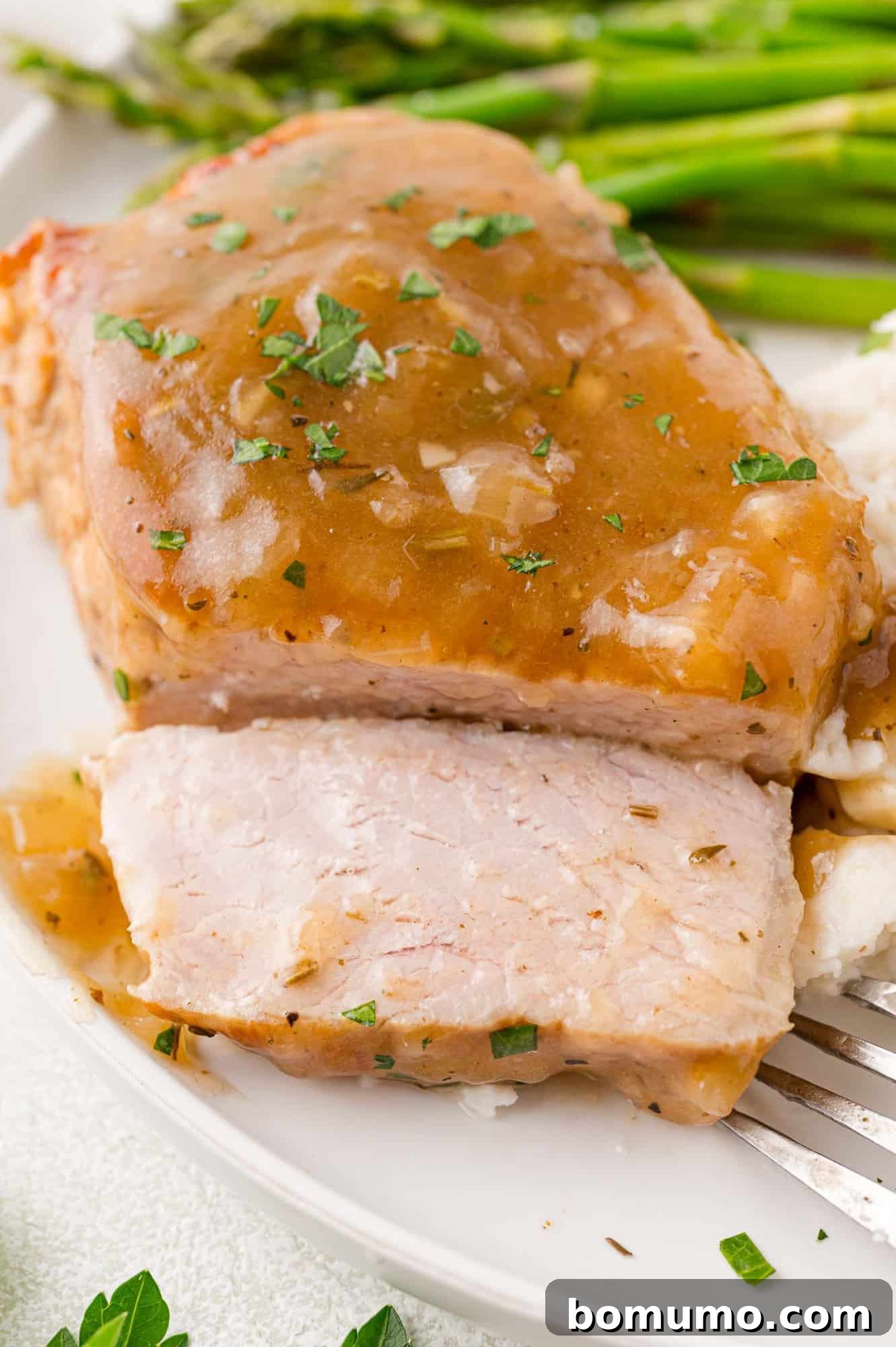 Instant pot pork chop, cut to show inside, topped with gravy.