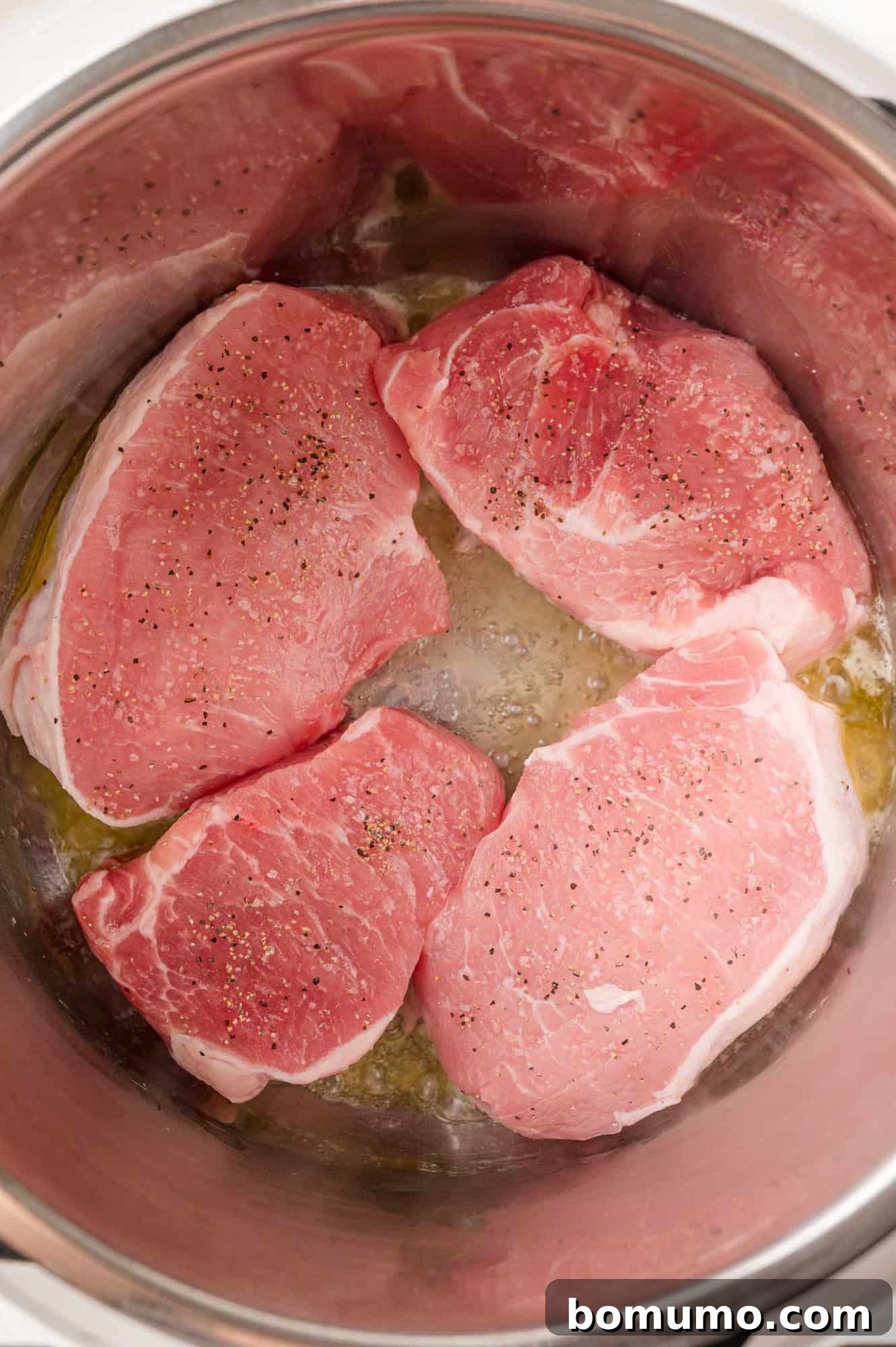 Pork chops in Instant pot, being seared.