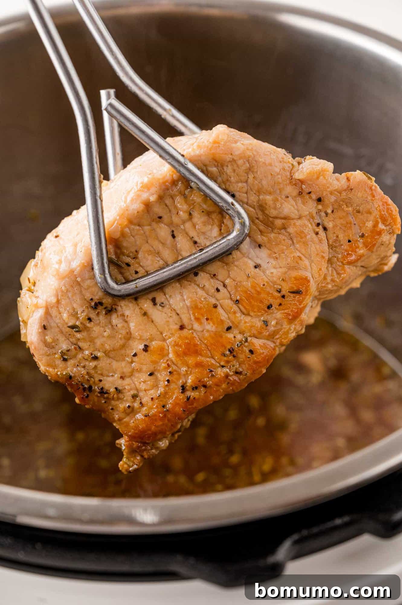 Browned pork chop being added back to Instant Pot.
