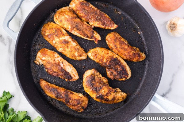 Golden brown chicken tenders perfectly seared in a hot skillet, showcasing the delicious crust achieved.