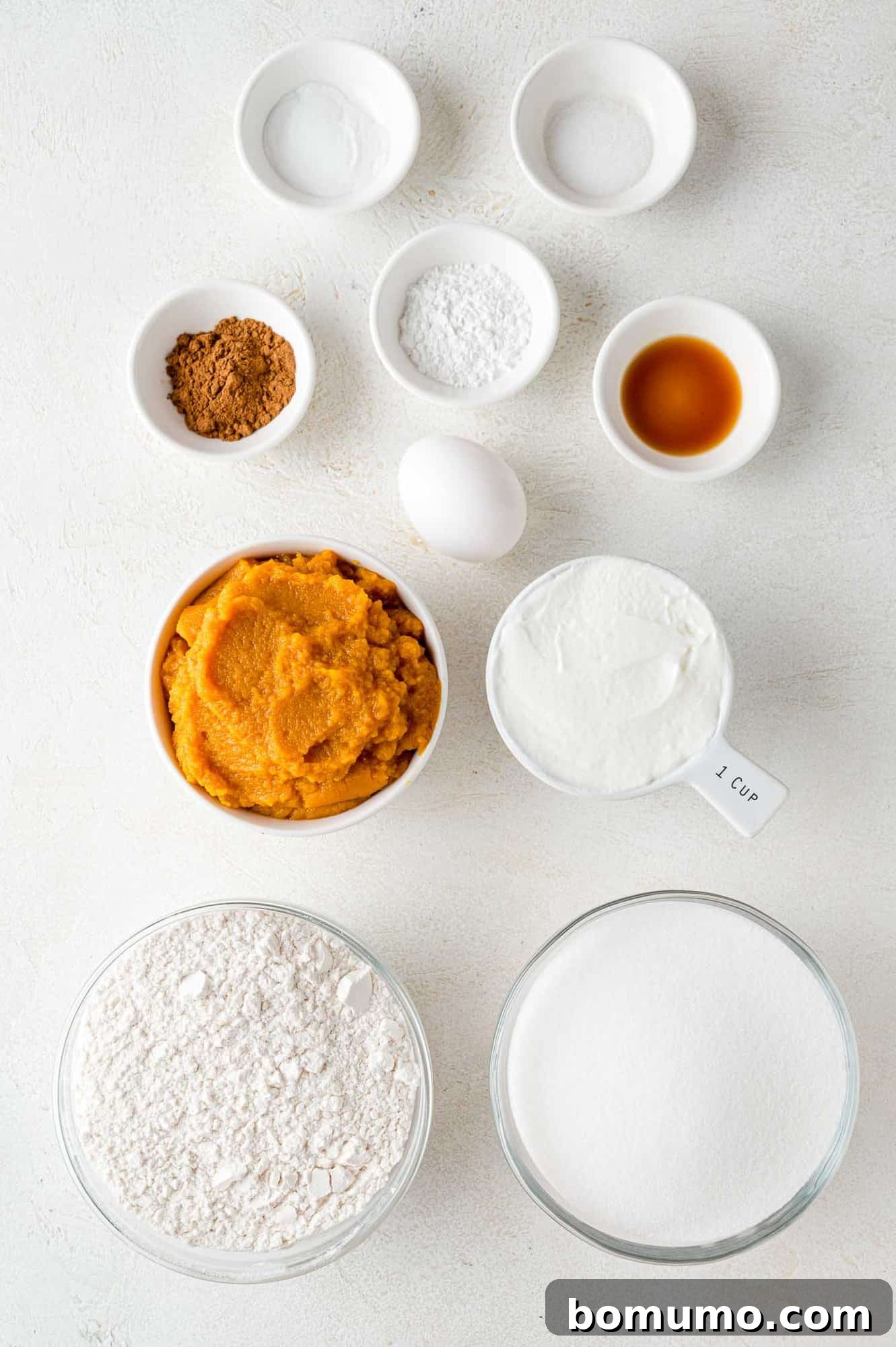 Autumn Pumpkin Spice Bars 3 A beautifully arranged spread of fresh, quality ingredients essential for baking the perfect pumpkin bars, including vibrant pumpkin puree, eggs, flour, and a blend of warm spices.