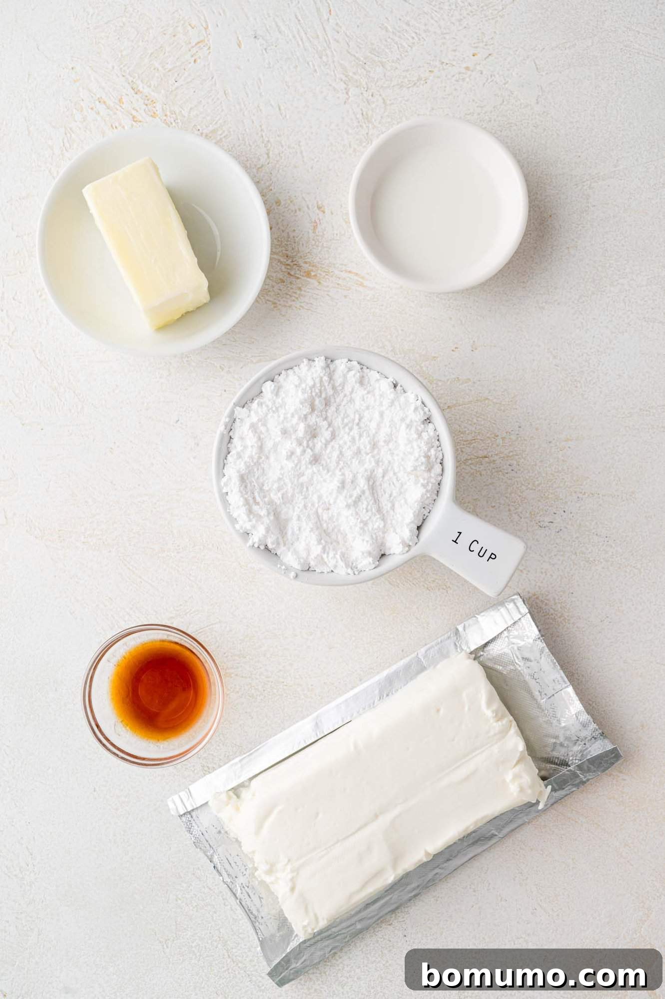 Autumn Pumpkin Spice Bars 4 A curated selection of fresh, premium ingredients required for crafting a rich and velvety cream cheese frosting, featuring softened cream cheese, butter, powdered sugar, and pure vanilla extract.