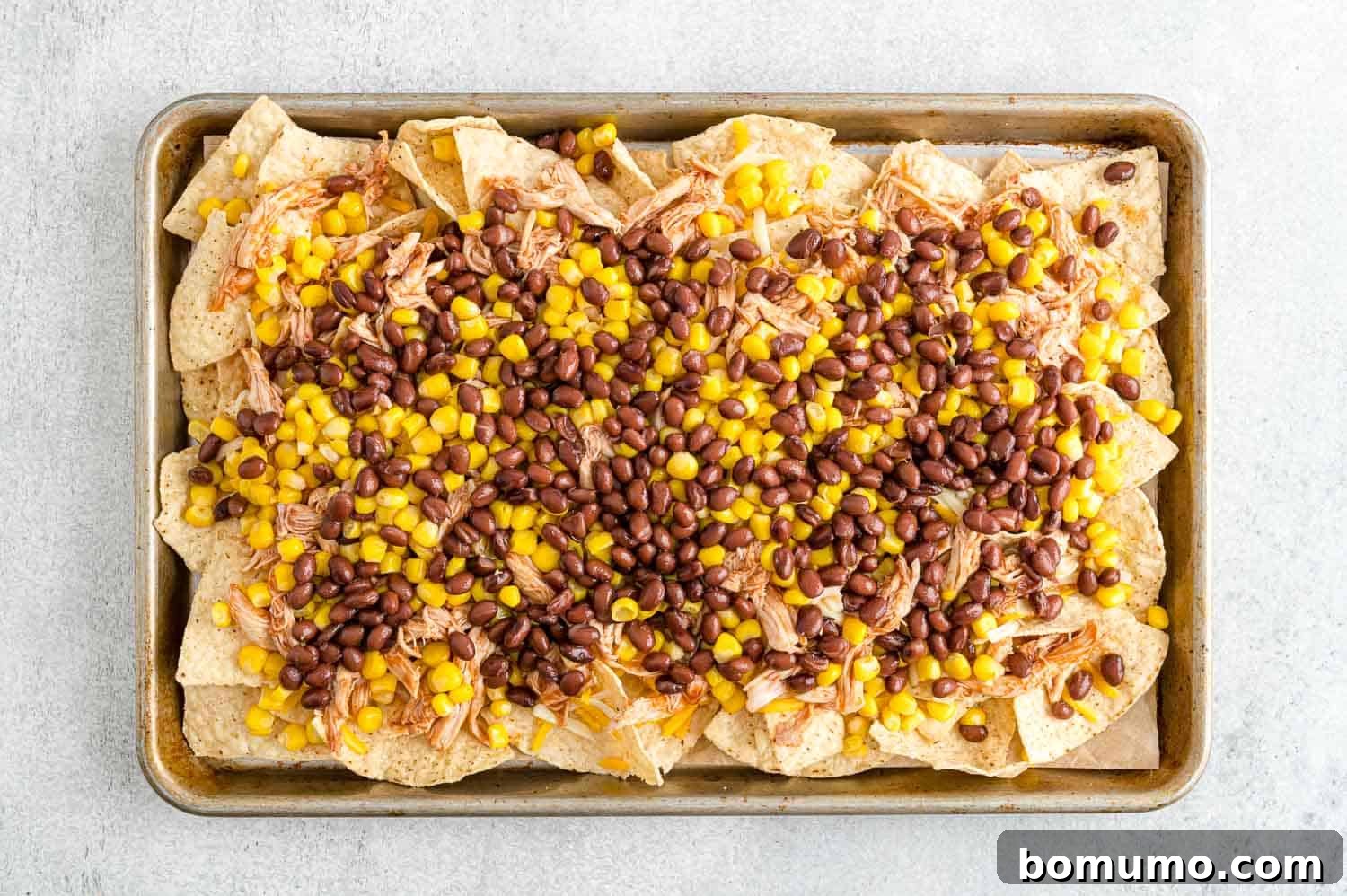 Backyard BBQ Chicken Nachos 11 Black beans scattered over the corn and chicken layers on the nachos, adding color and texture.