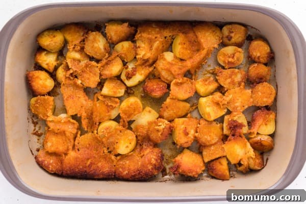 Crispy Roasted parmesan potatoes in a baking dish, golden brown.