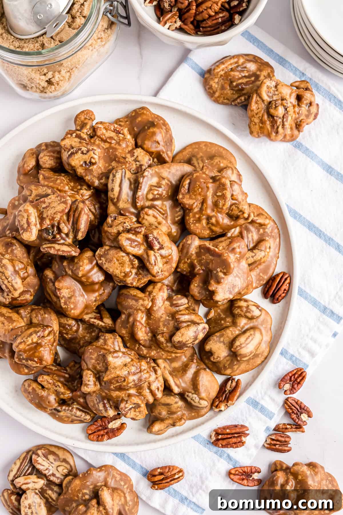 Pecan pralines piled up on a white platter.