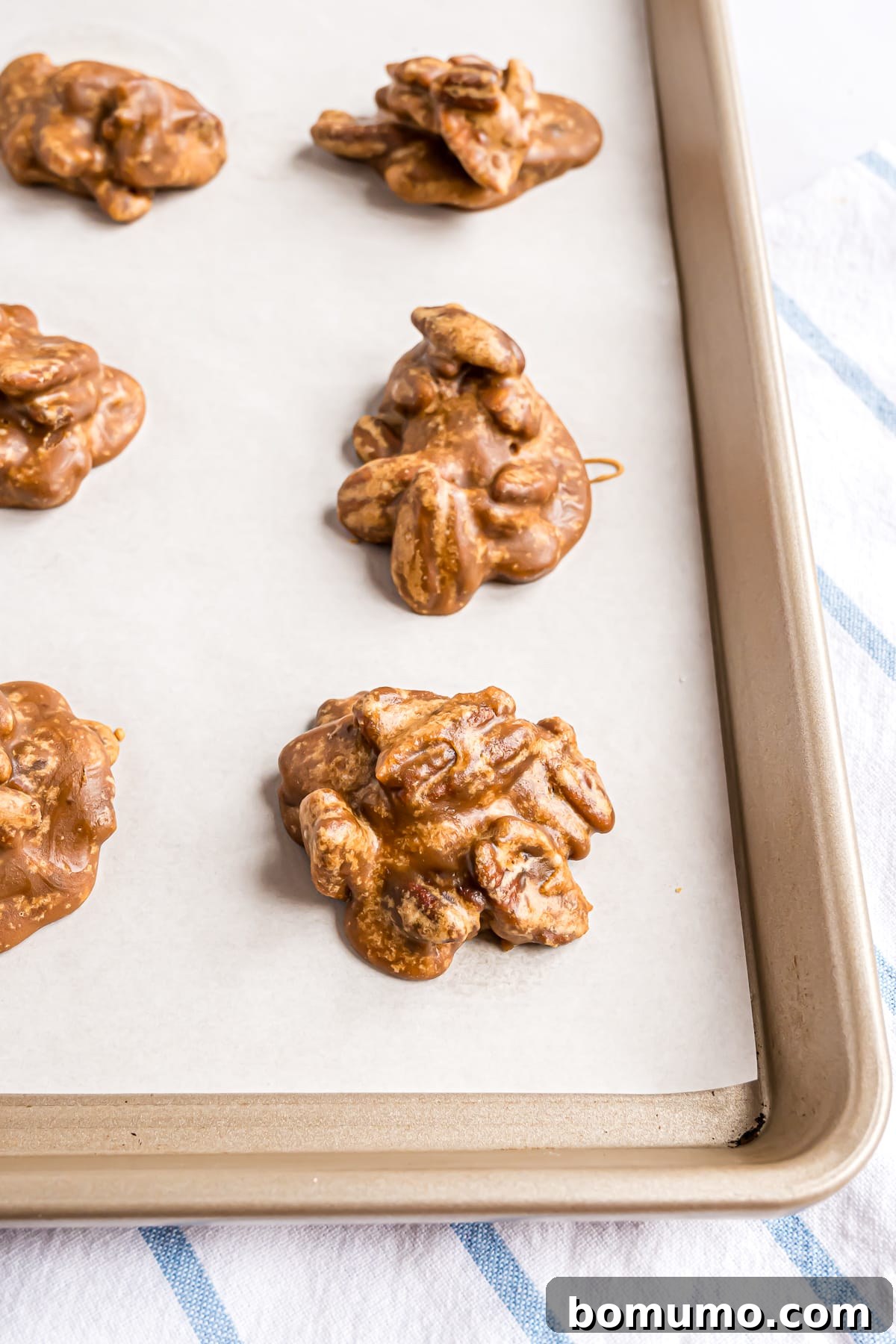 Pralines cooling on a parchment paper lined sheet.